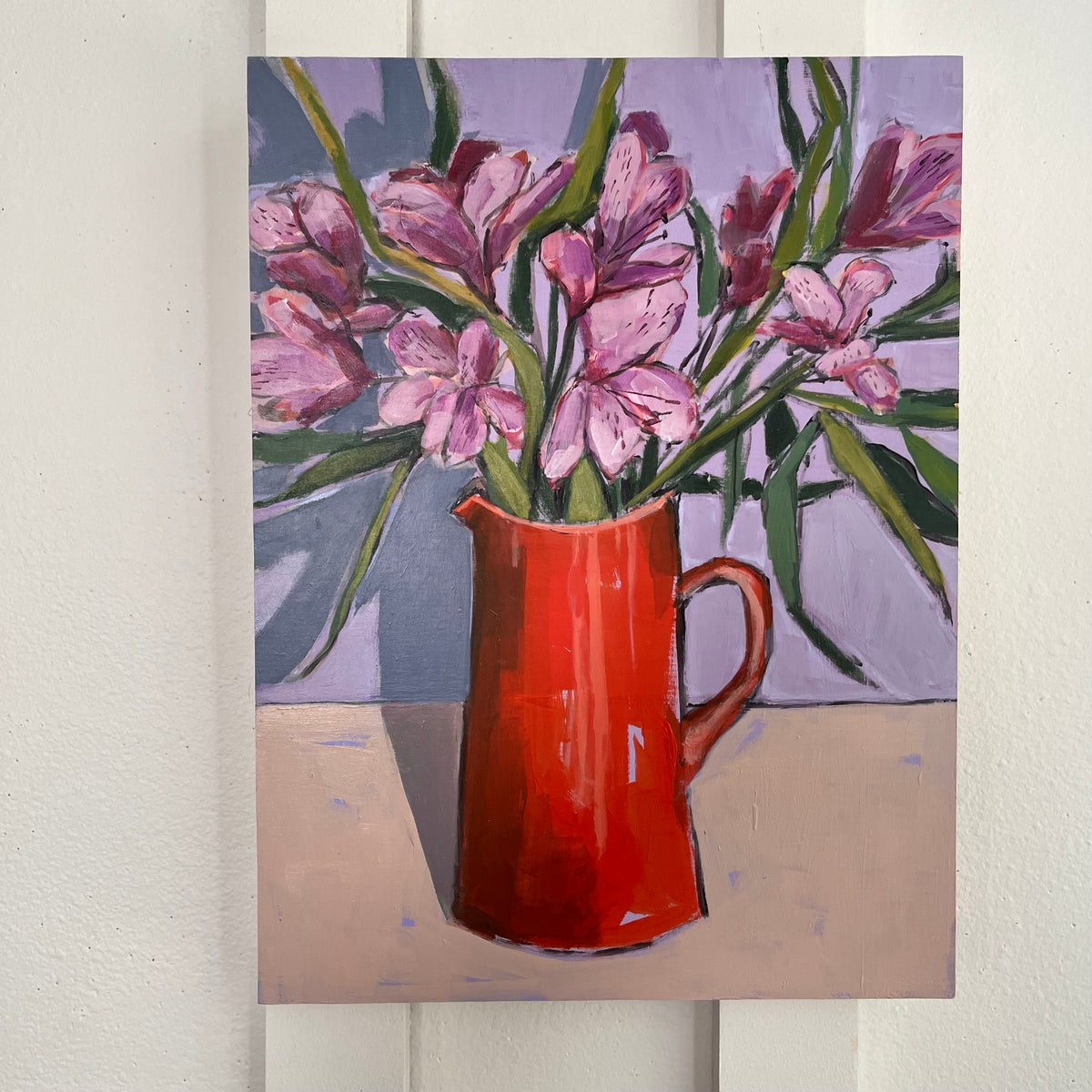 Red Pitcher no 2 — pink flowers and green stems in a tall red pitcher against a lavender background. Painting by Maggie Stickney.