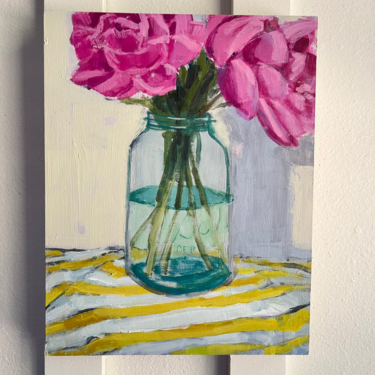 Peonies — deep pink peonies in a green glass jar on a yellow-and-white striped cloth. Painting by Maggie Stickney.