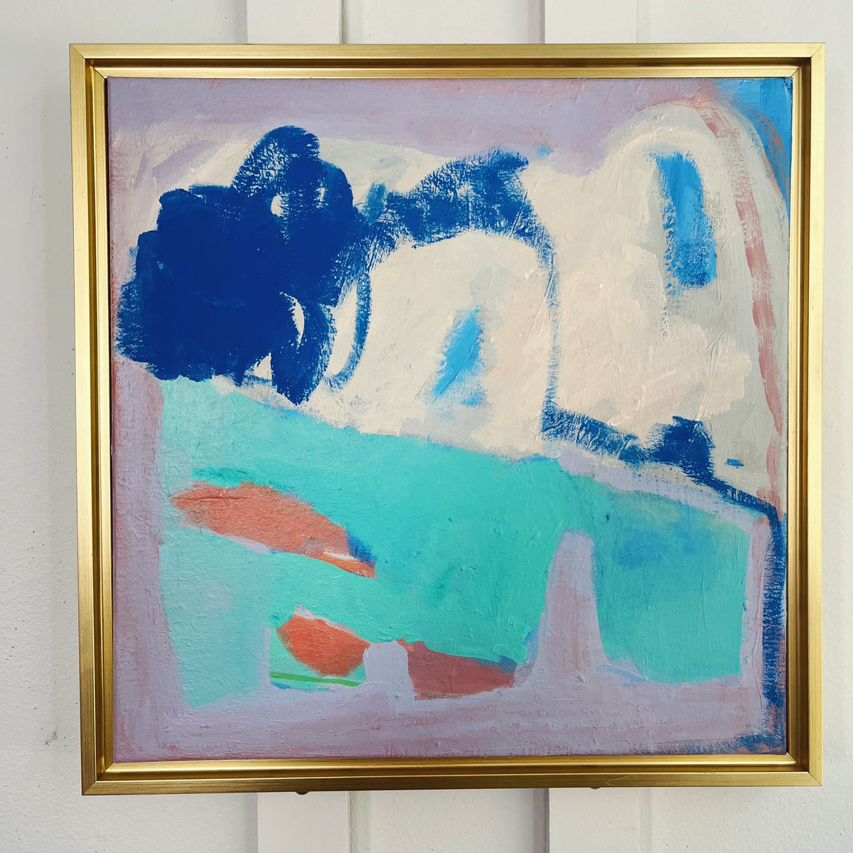 Dropped the Ball — abstract shapes in deep blue, turquoise, coral, and lavender, shown in a gold-colored frame. Painting by Maggie Stickney.